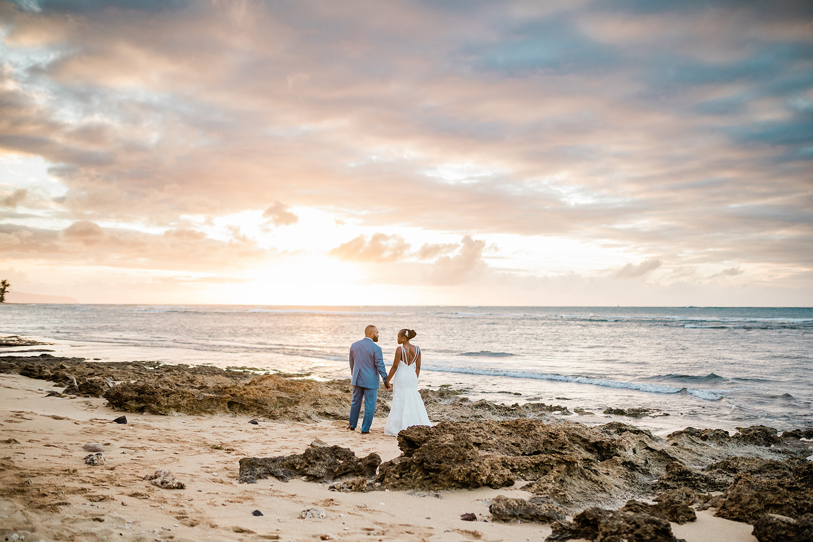 bride and groom getting married in hawaii during the sunset