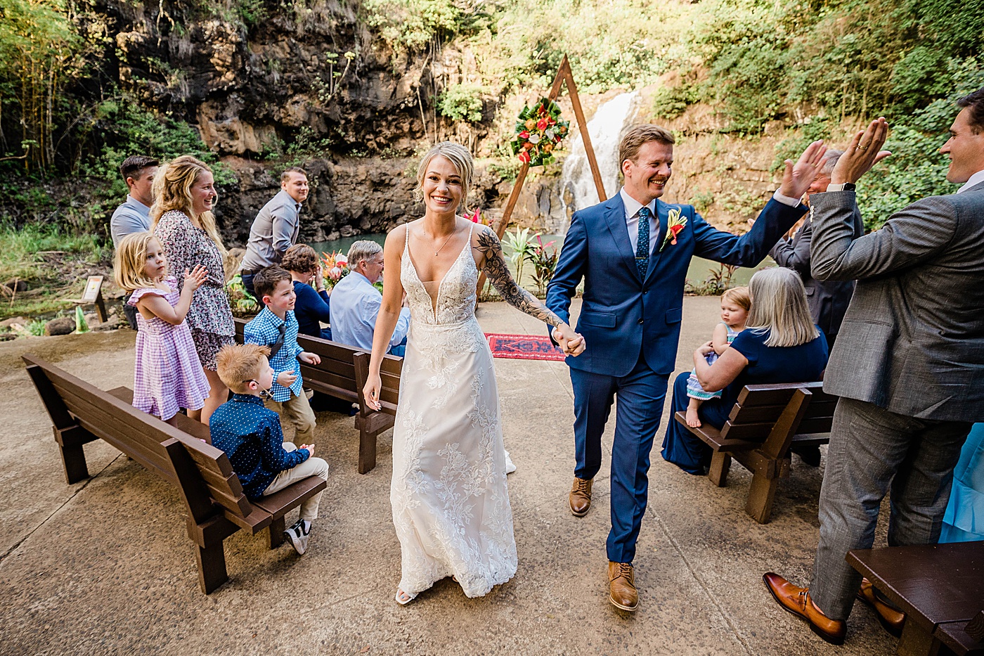 Bride and groom celebrating walking down the aisle at Waimea Valley wedding.