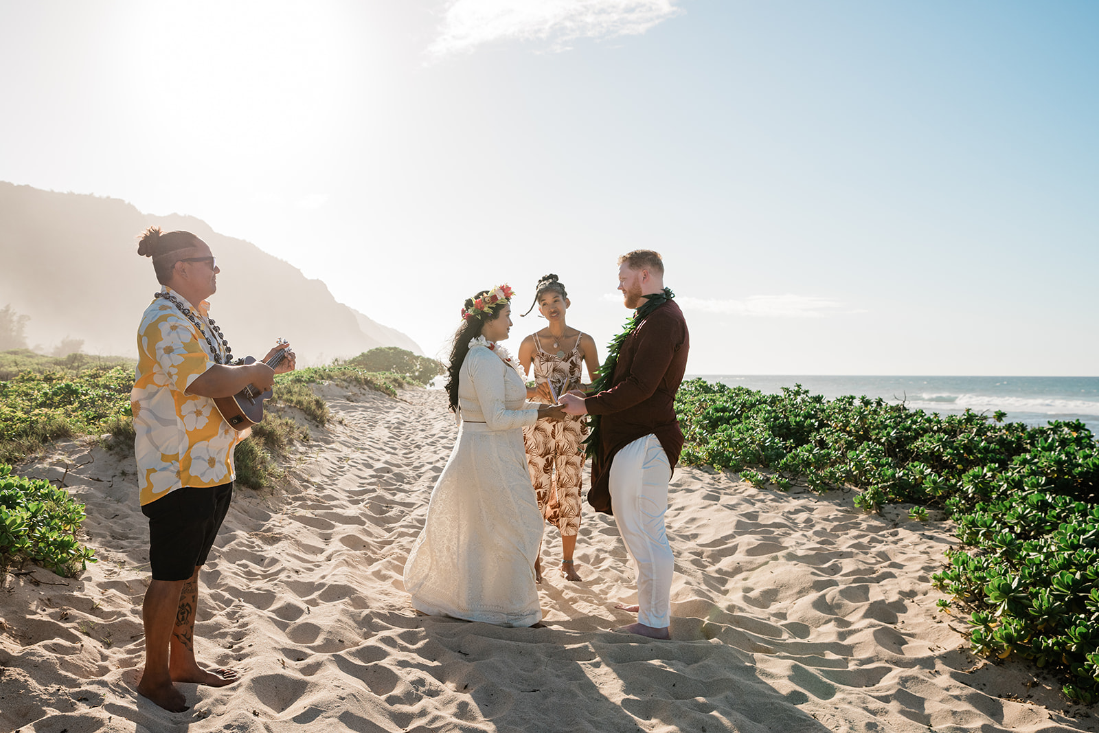Couple enjoying their all-inclusive elopement in Hawaii with florals and live ukulele music
