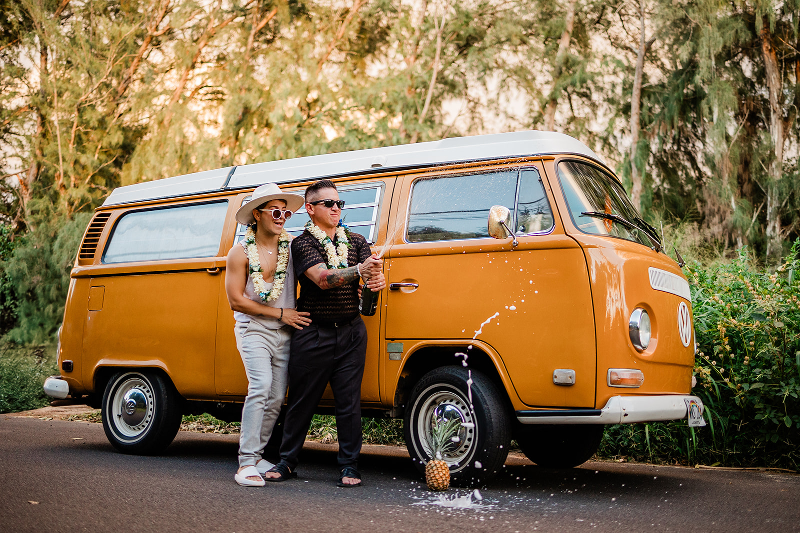 Two grooms standing in front of a vintage VW bus during their LGBTQ+ elopement in Hawaii
